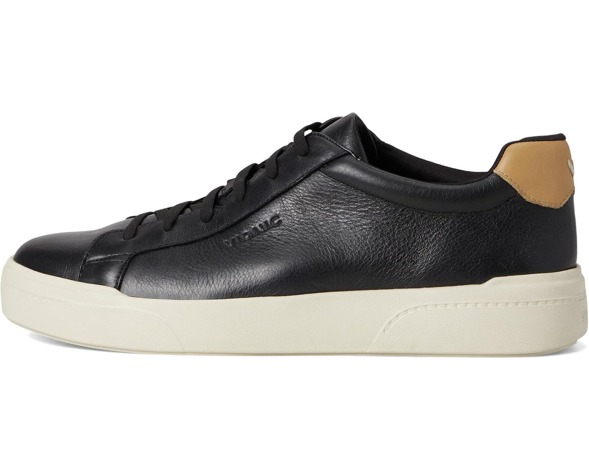 Black leather low-top sneaker with tan heel tab and off-white sidewall
