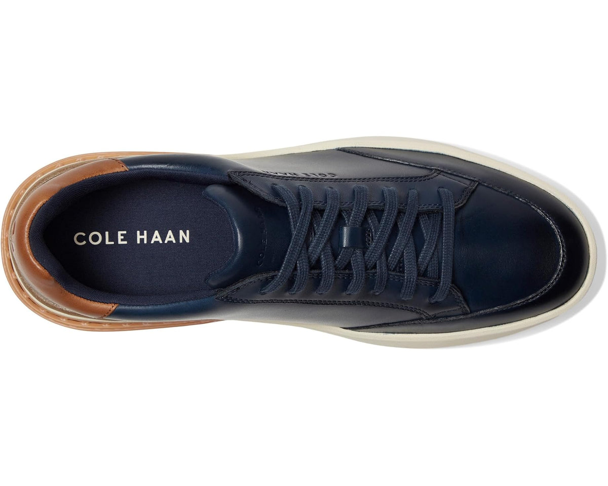Cole Haan navy low-top sneaker, lace-up, brown heel tab, cream sole.