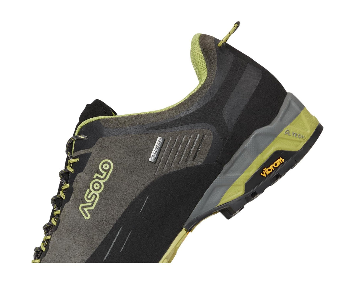 Men's trail shoe quarter view, dark gray upper with lime side panel and Vibram