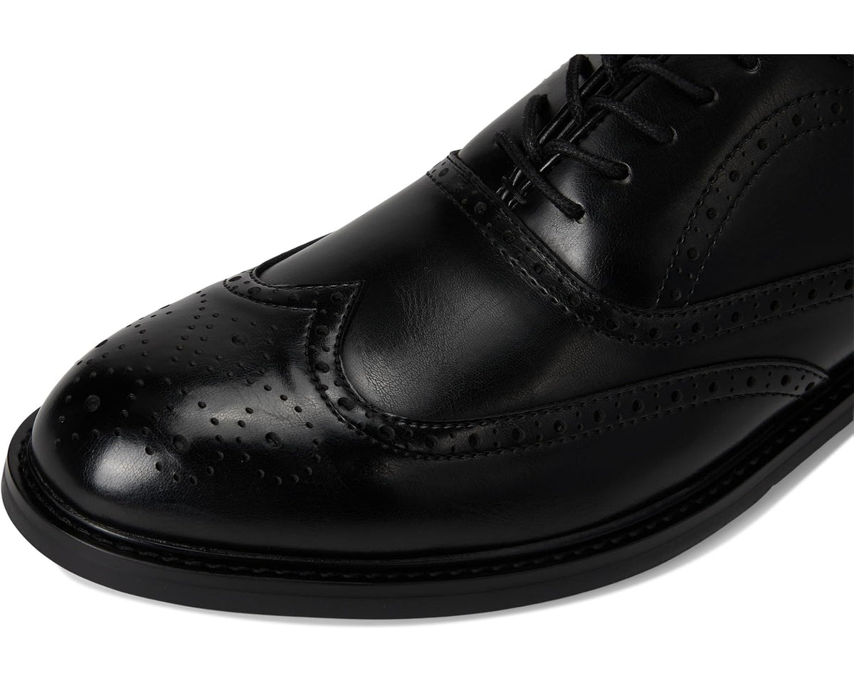 Black leather oxford dress shoe toe and lace-up front with brogue perforations.