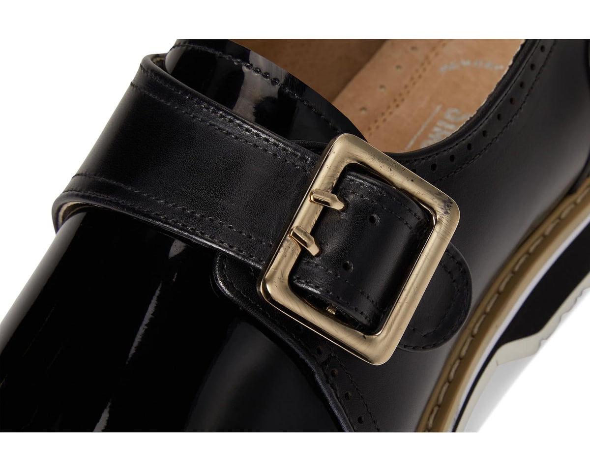 Men's black monk strap shoe close-up of square buckle and stitched strap
