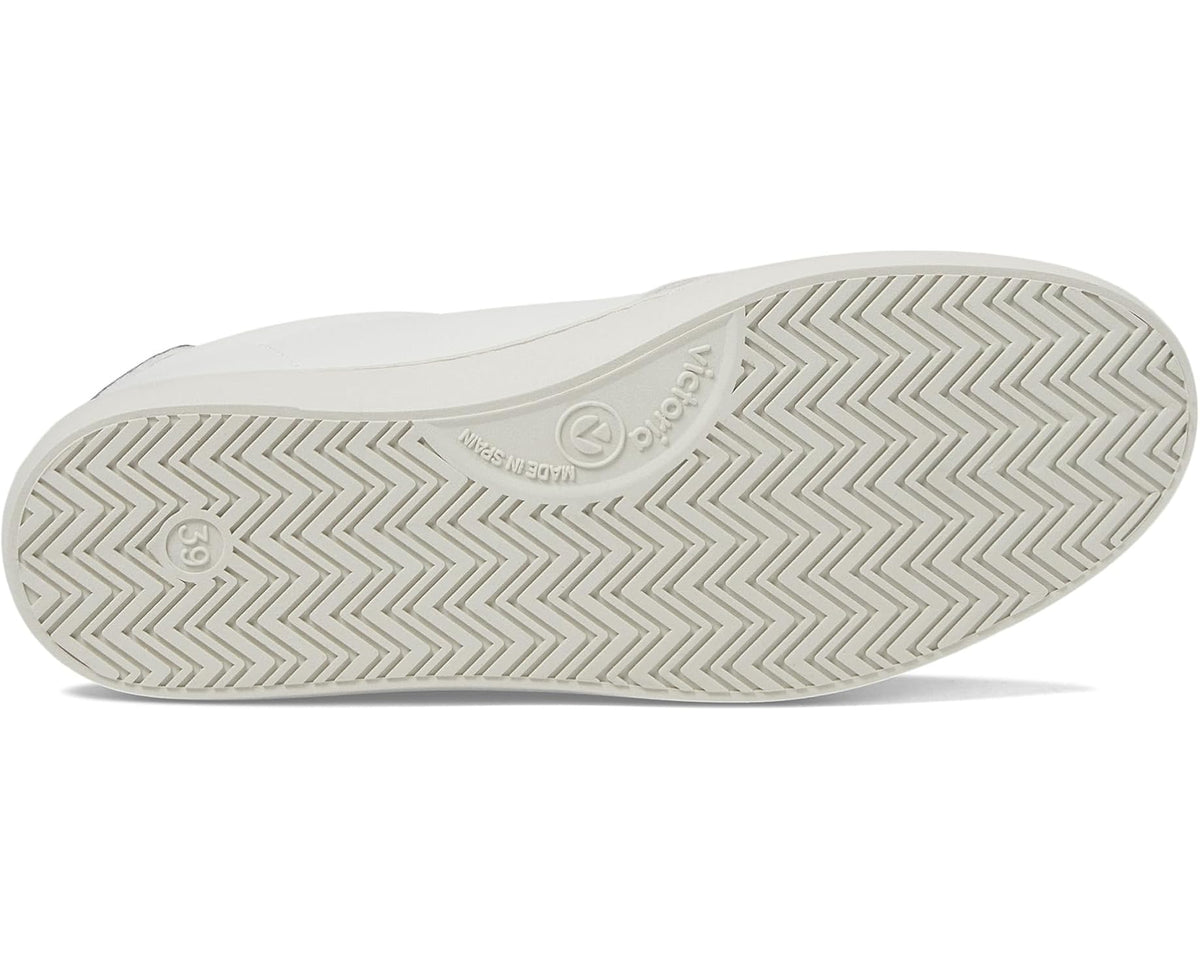 Unisex sneaker outsole with zigzag tread pattern under white low-top shoe