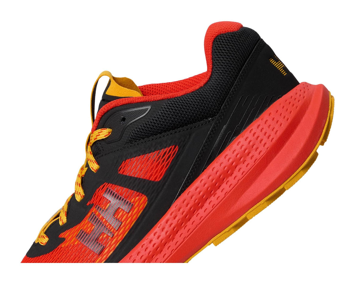 Men's trail running shoe side view with red mesh, black overlays, and yellow accents.