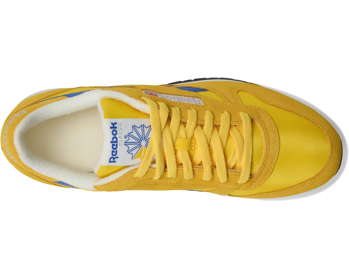 Reebok leather sneakers with yellow suede upper, white interior, and blue side stripe.