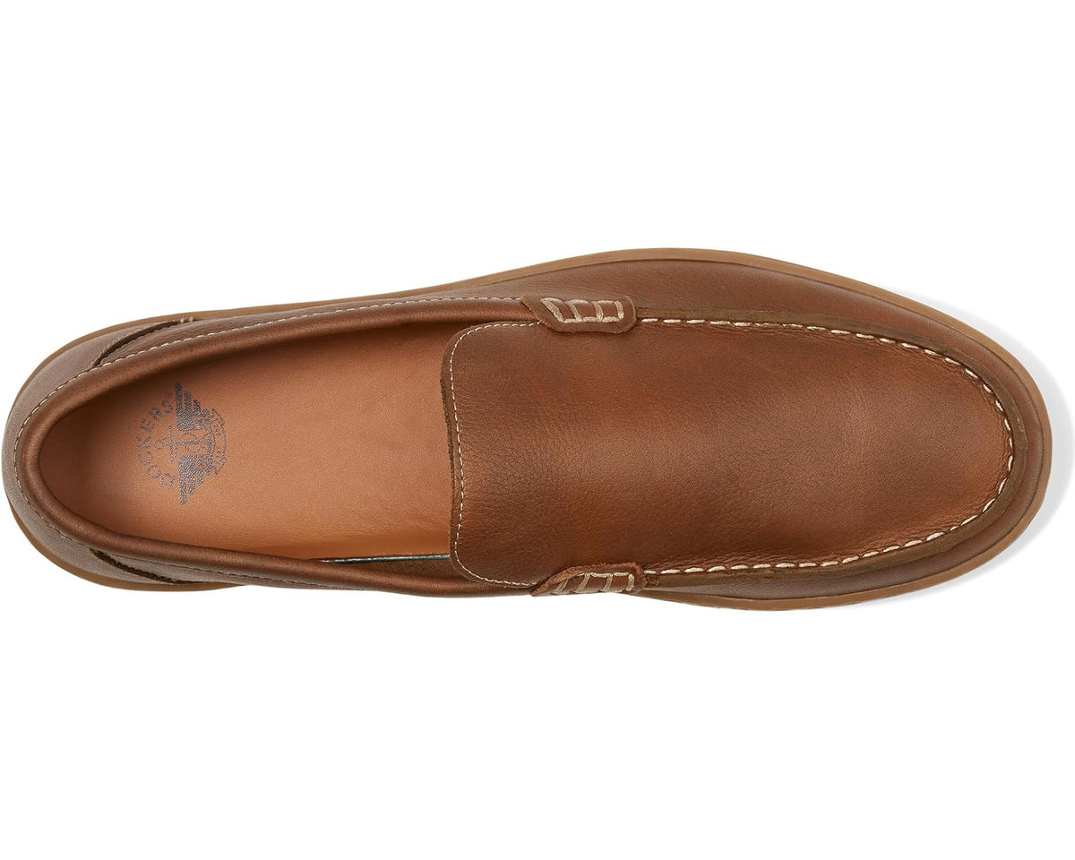 Tan leather-look slip-on loafer side view with stitched upper and footbed emblem