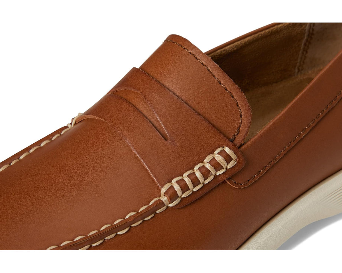 Tan leather loafer close-up with braided keeper strap and stitched seams