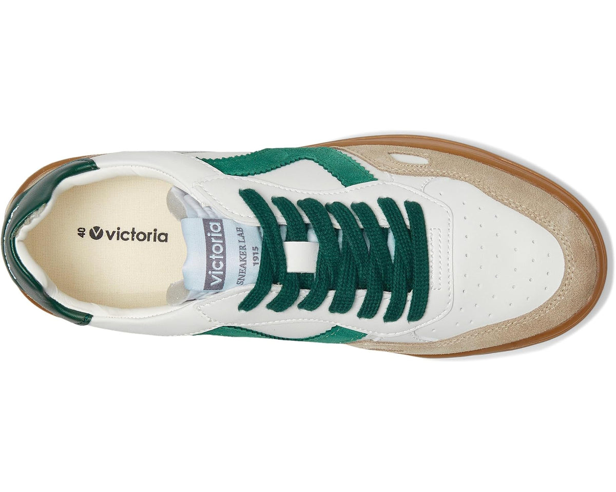 Side view of green lace-up sneakers with suede panels and thick caramel sole