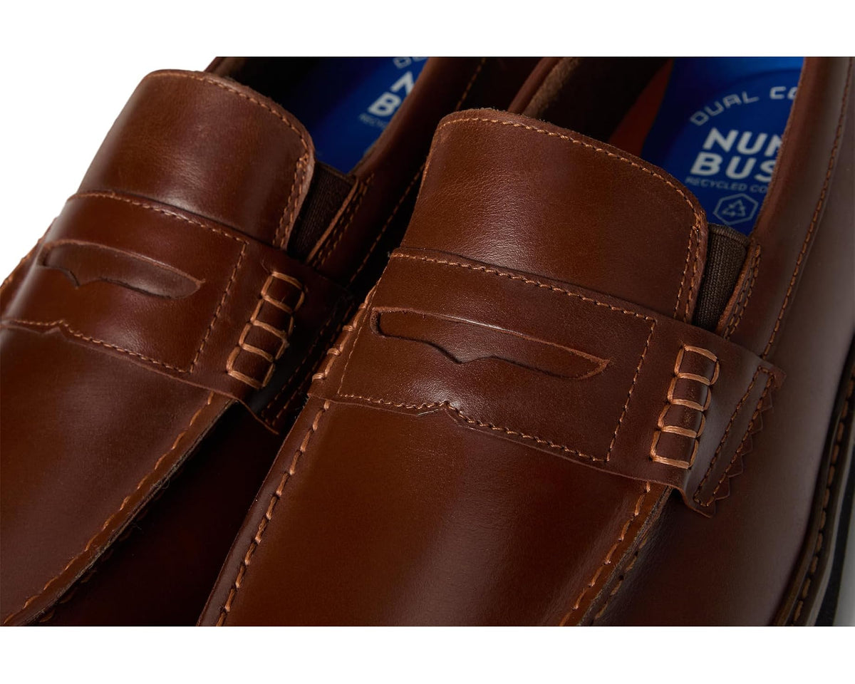 Cognac leather penny loafer close-up of strap hardware and side panel stitching