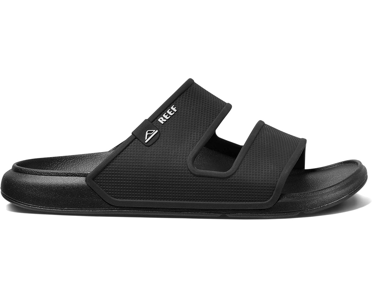 Men's black REEF slide sandals with wide adjustable strap and textured upper