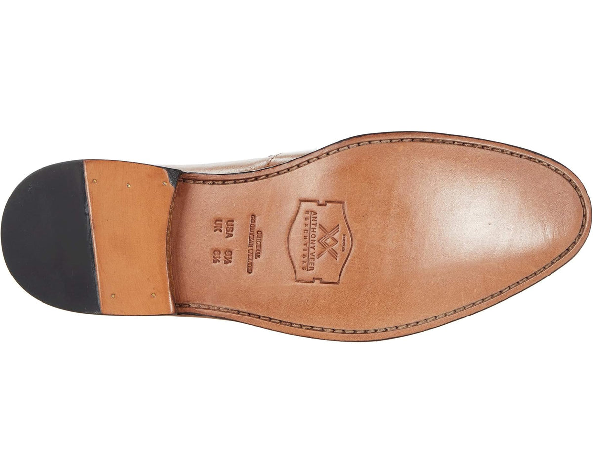 Tan leather penny loafer outsole and heel underside view with brand stamp