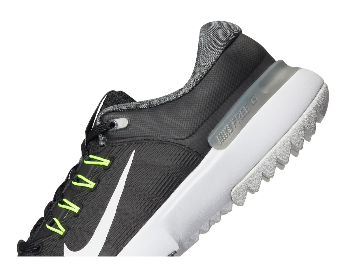 Nike golf shoe side view, black and grey upper with white midsole and neon green trim.