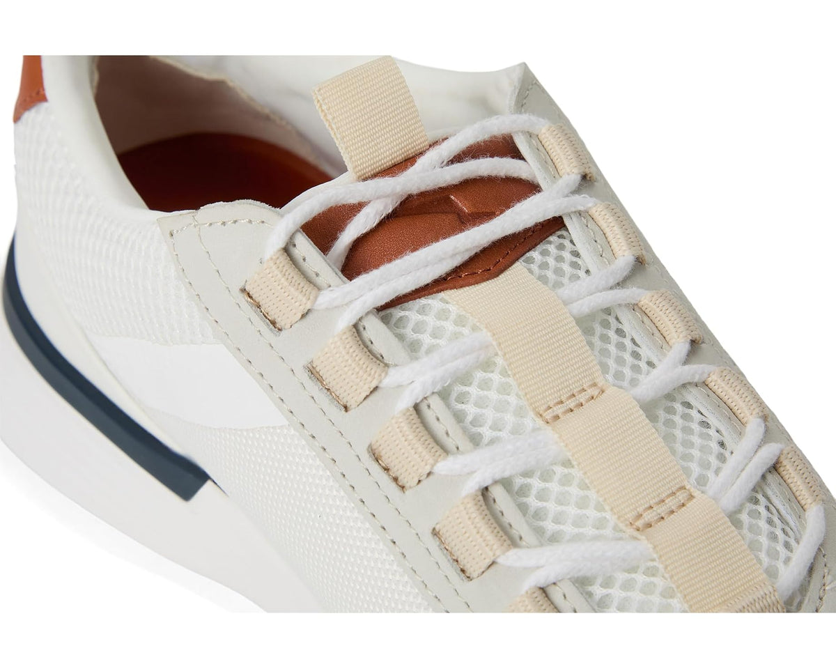 Close-up of white lace-up sneakers with beige straps and woven textile panels