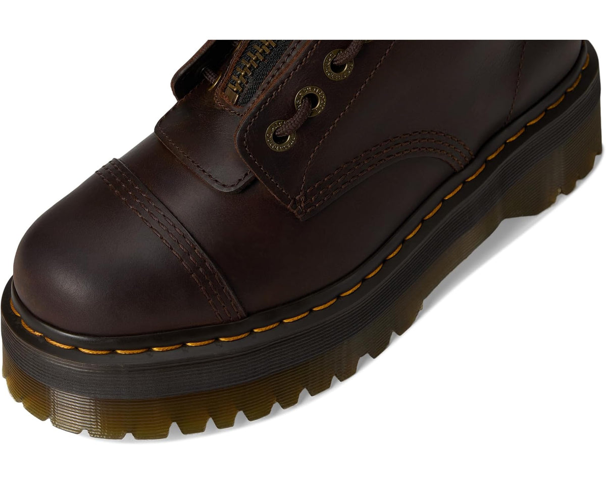 Dark brown leather lace-up platform boots with yellow welt stitching, side close-up.