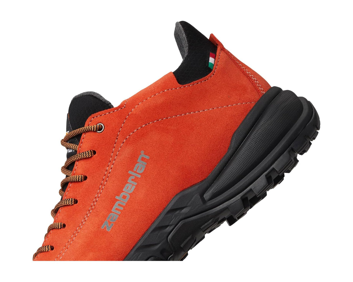 Orange suede hiking shoe quarter view with lace-up closure and black tread sole