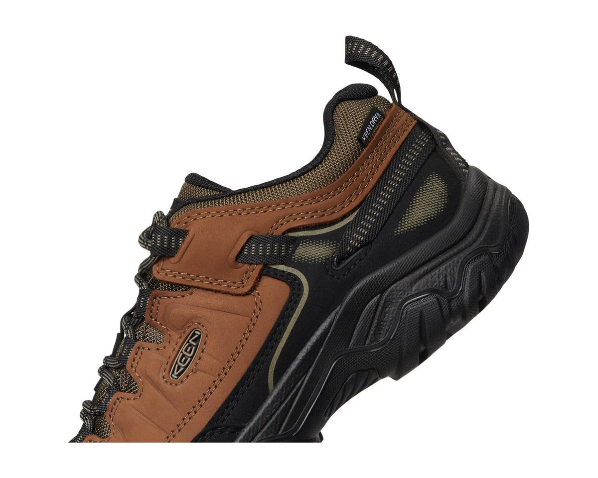 Men's mid hiking shoe quarter view with lace eyelets and layered upper panels