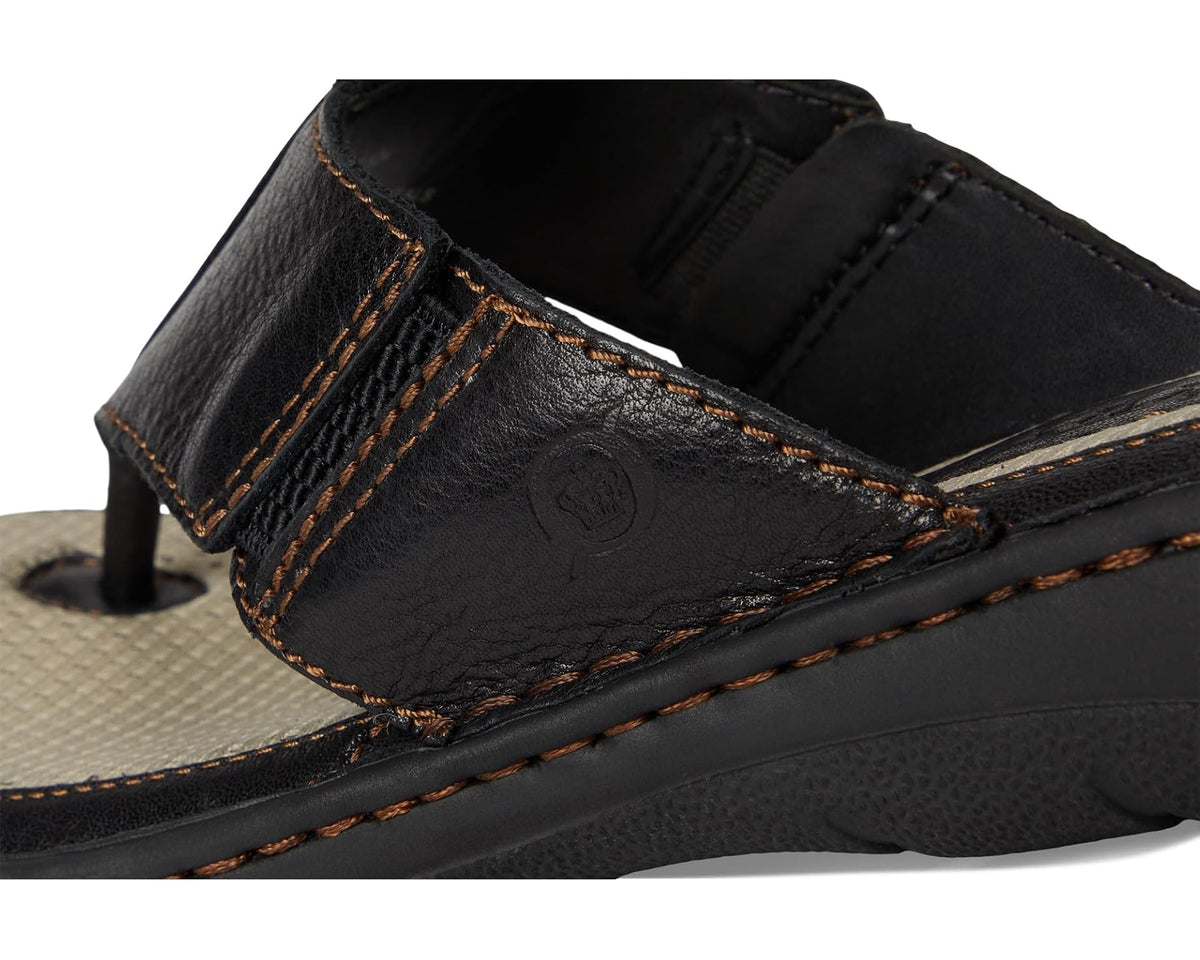 Men's black leather slide sandal close-up, orange stitching and embossed logo on strap