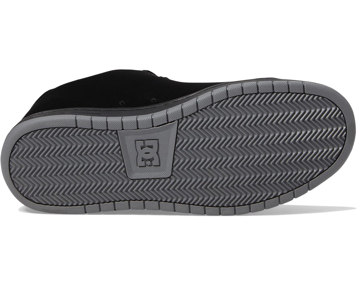 Black skate sneakers with textured rubber outsole and DC emblem on heel.