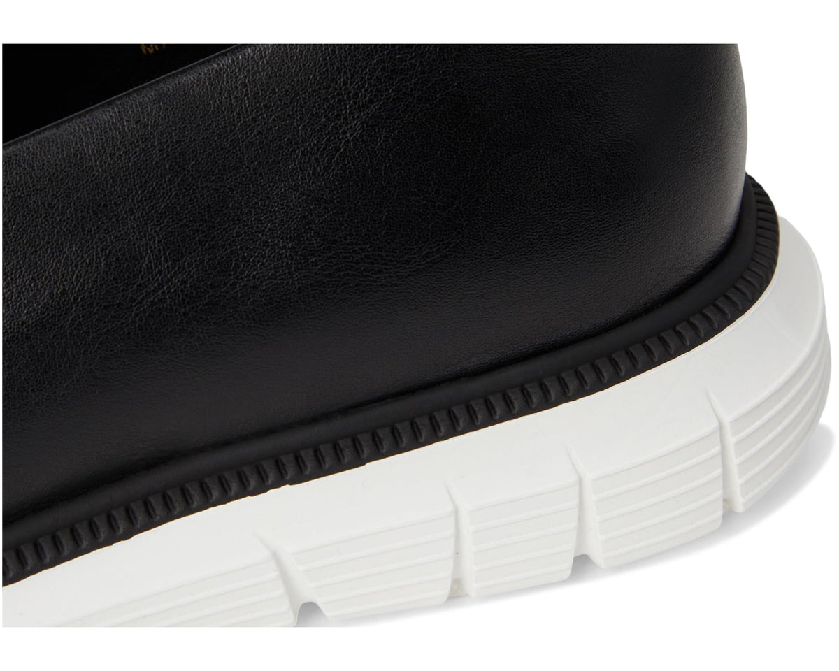 Men's black leather loafer close-up of textured edge and white rubber sole tread