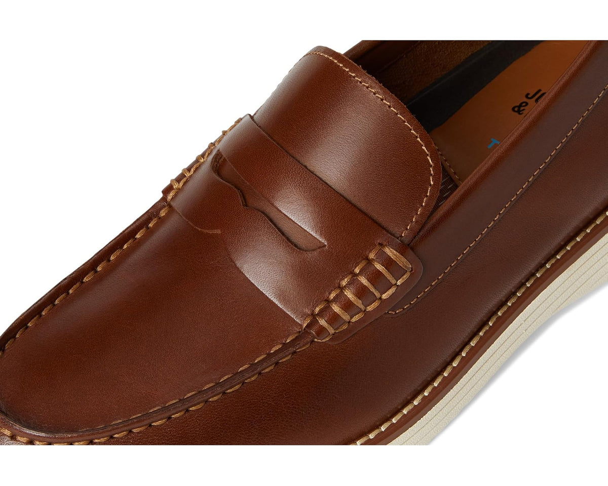 Men's penny loafer close-up, brown leather penny strap and moc-toe stitching on upper