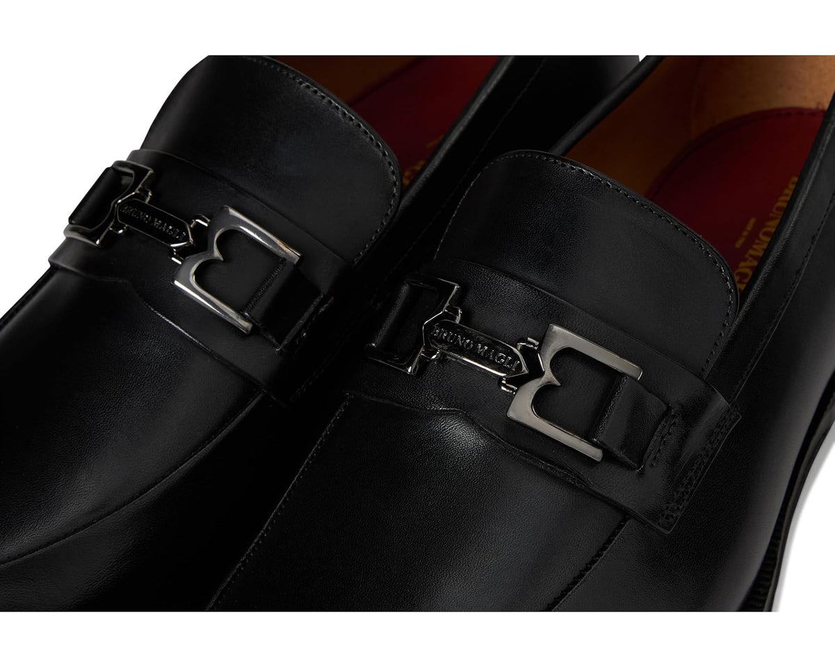 Men's black leather loafer close-up of metal bit and strap buckles