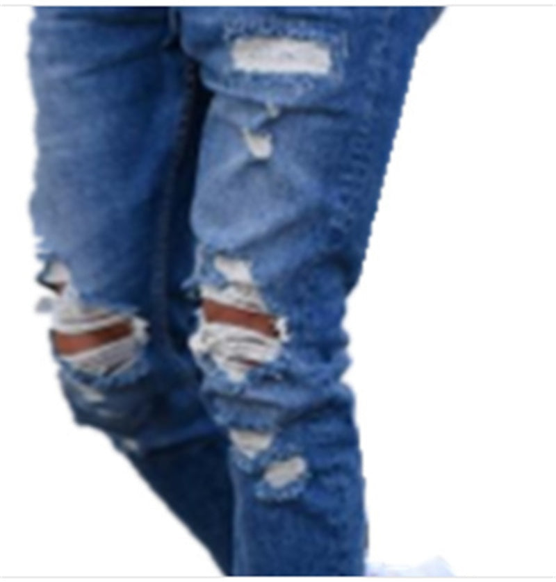 Close-up of deep blue ripped denim jeans with distressed knee and thigh holes