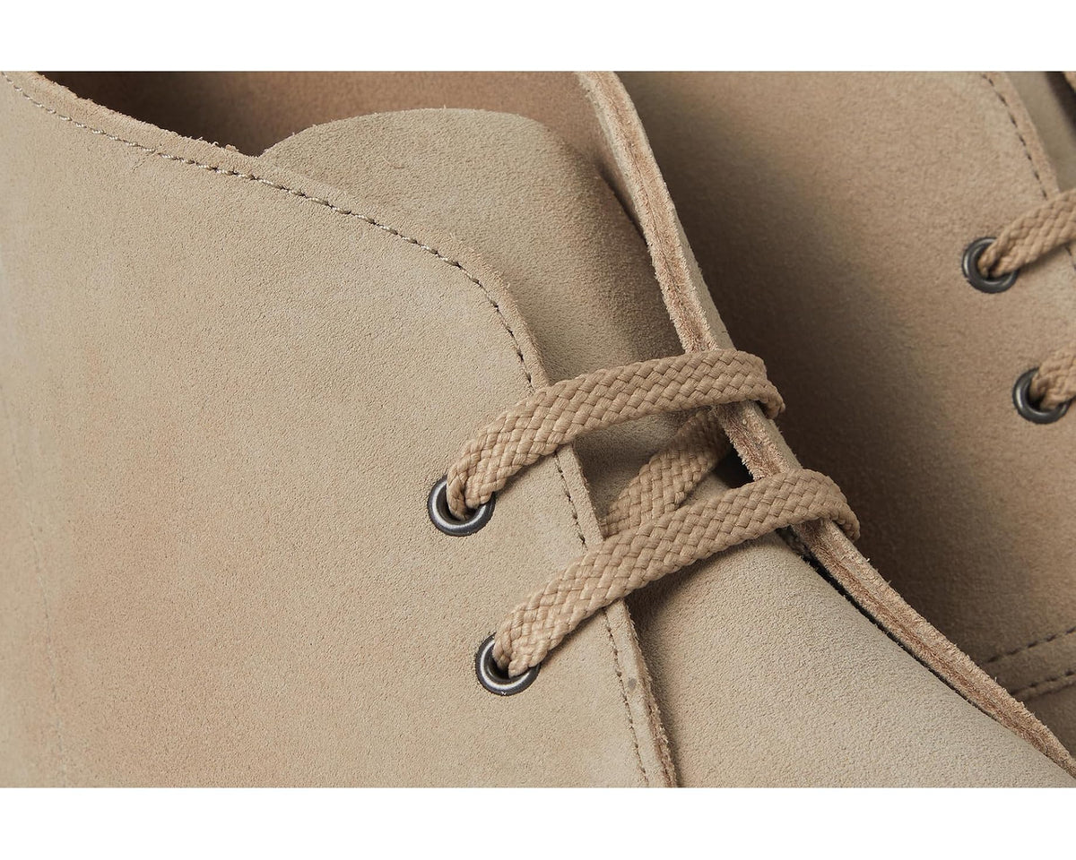 Sand suede boot close-up of lace-up eyelets and stitched upper panel.