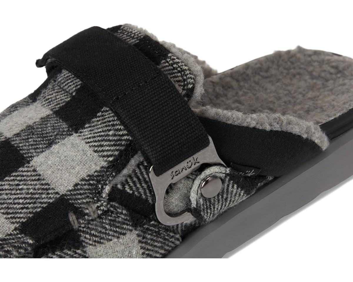 Close-up of black strap, metal hardware, and black/grey plaid fabric upper