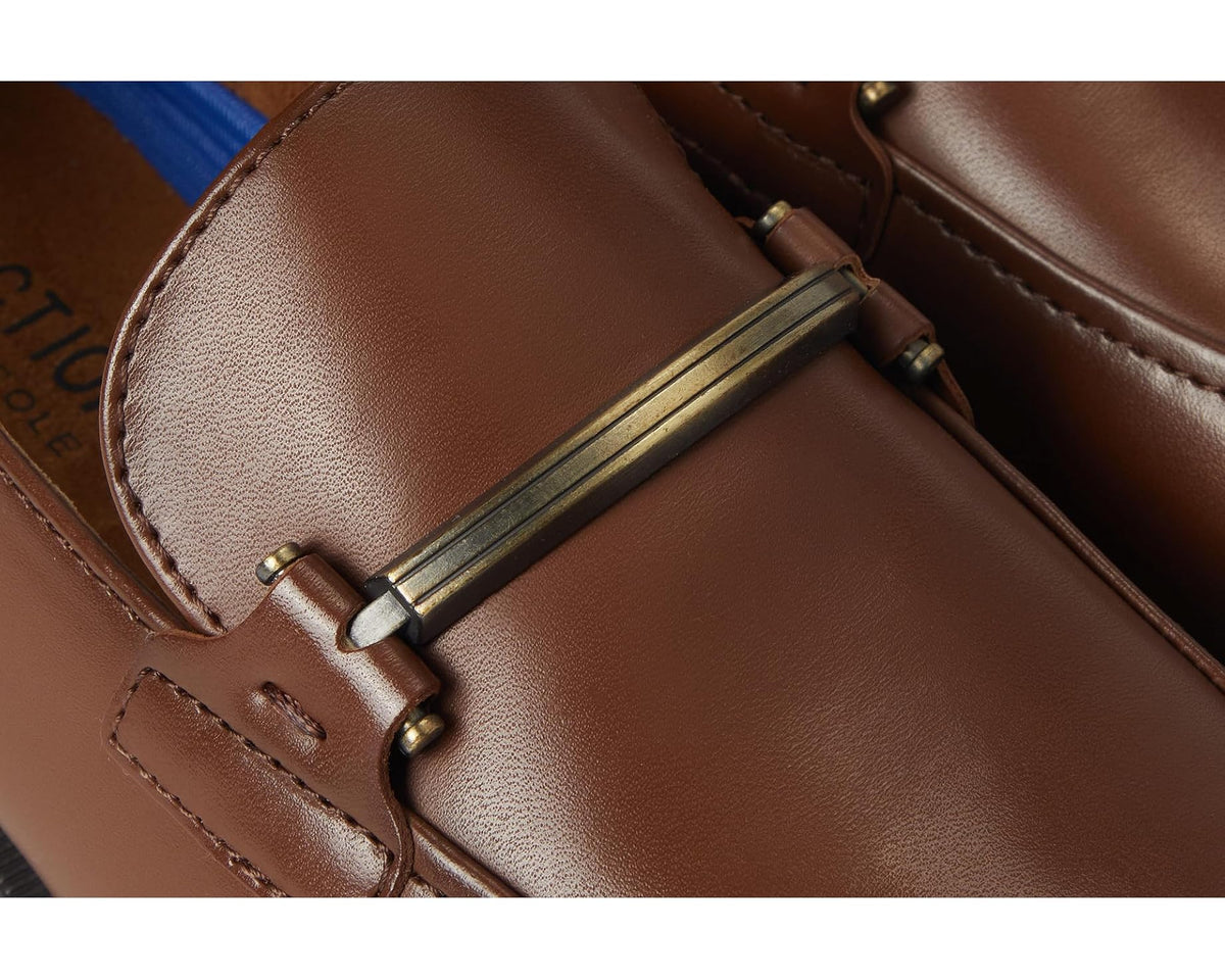 Close-up of brown loafer strap keeper with brass-toned hardware and stitching