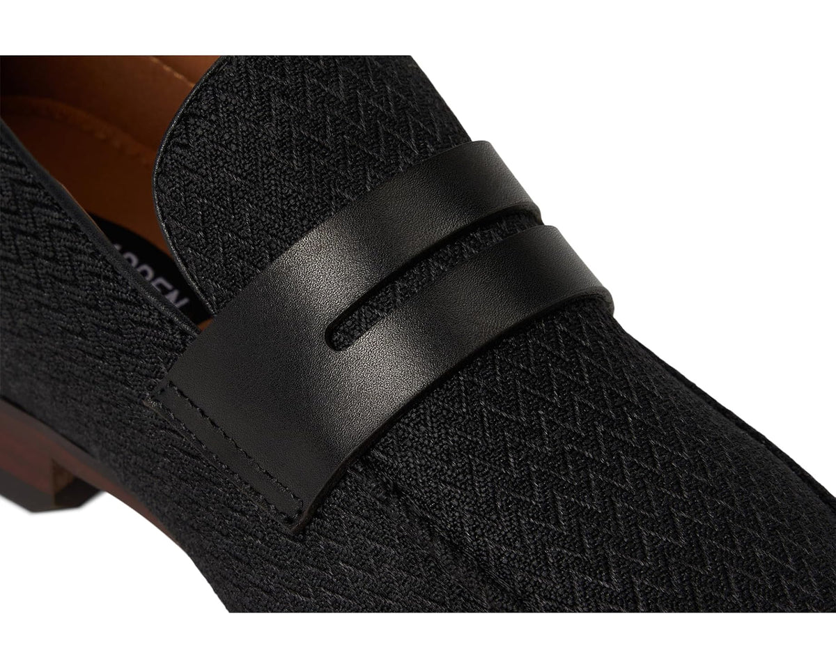Black loafer strap and textured upper close-up, with stitched edges