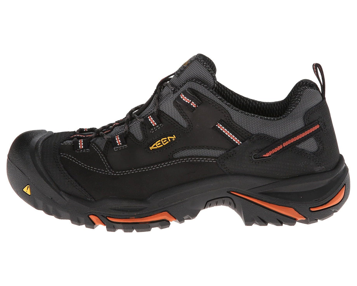 KEEN Braddock Low men's black steel-toe work sneaker, angled side view, orange accents