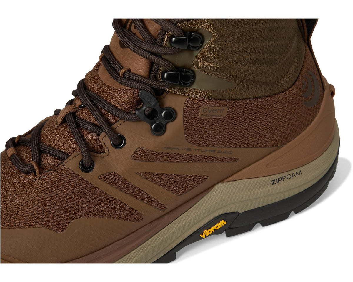 Cognac brown high-top boot close-up with laces, mesh panels, and Vibram outsole