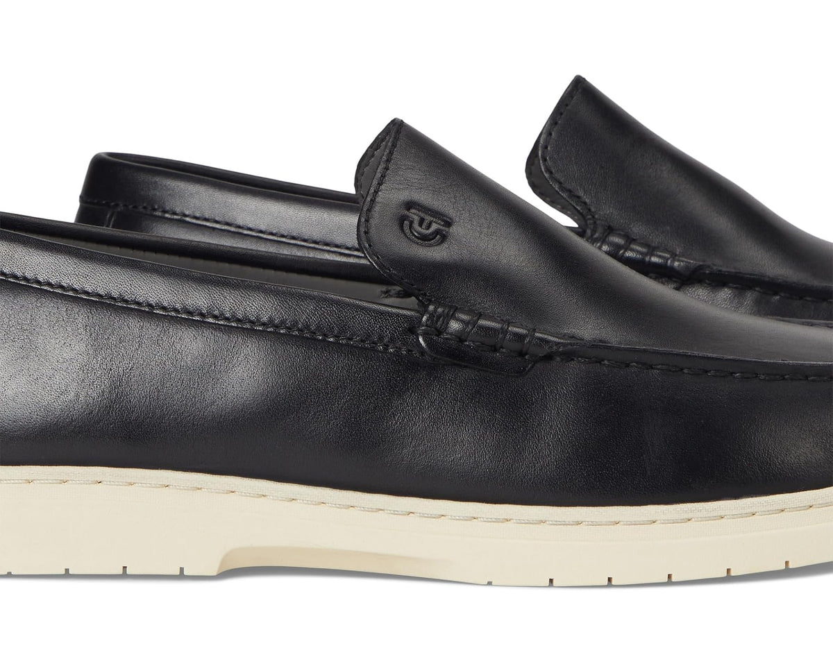 Black leather loafer close-up with stitched vamp and penny keeper