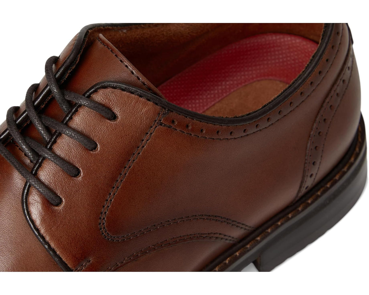 Close-up of brandy lace-up dress shoe with red interior lining and eyelets