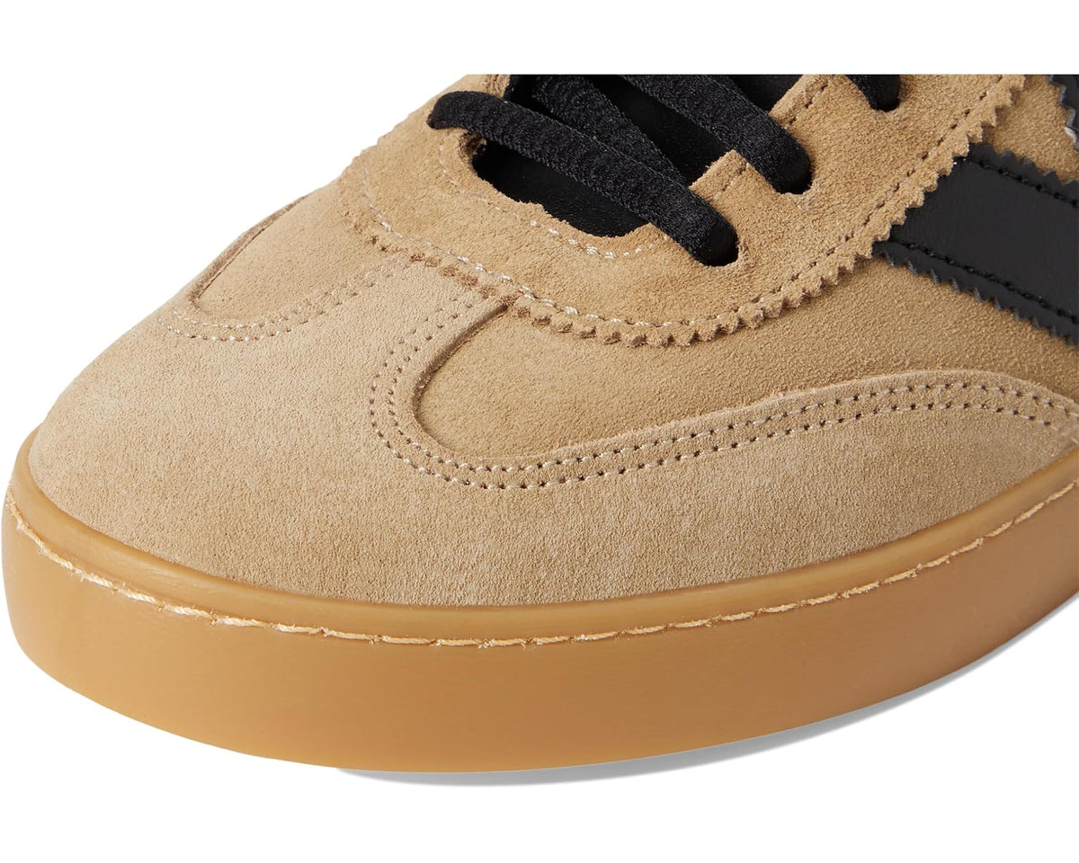 Close-up of beige suede upper, stitching, and black strap lace loops