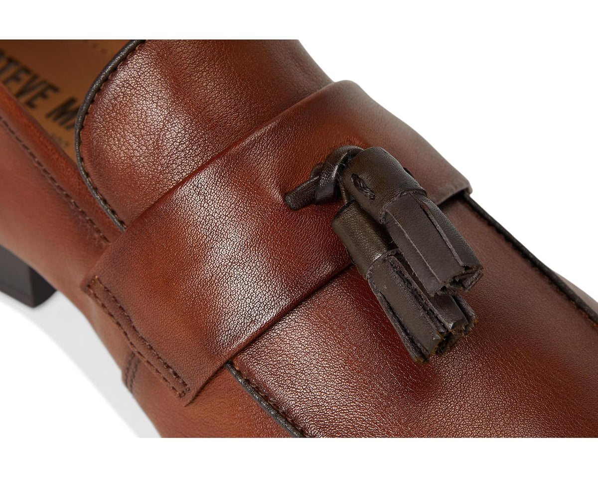Tan leather loafer close-up with tassel hardware and stitched vamp seam
