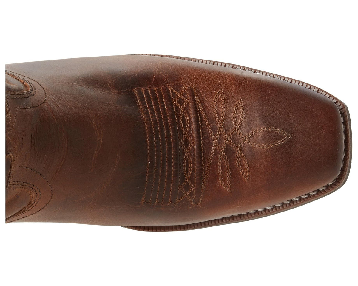 Rust-brown boot toe and side with embossed floral embroidery and distressed leather