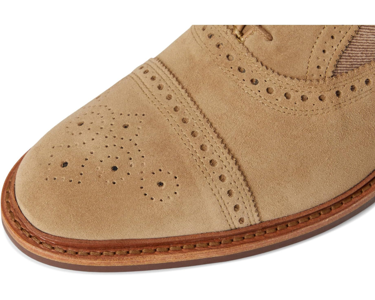 Men's bone suede oxford shoe toe with perforated brogue pattern and stitched sole edge