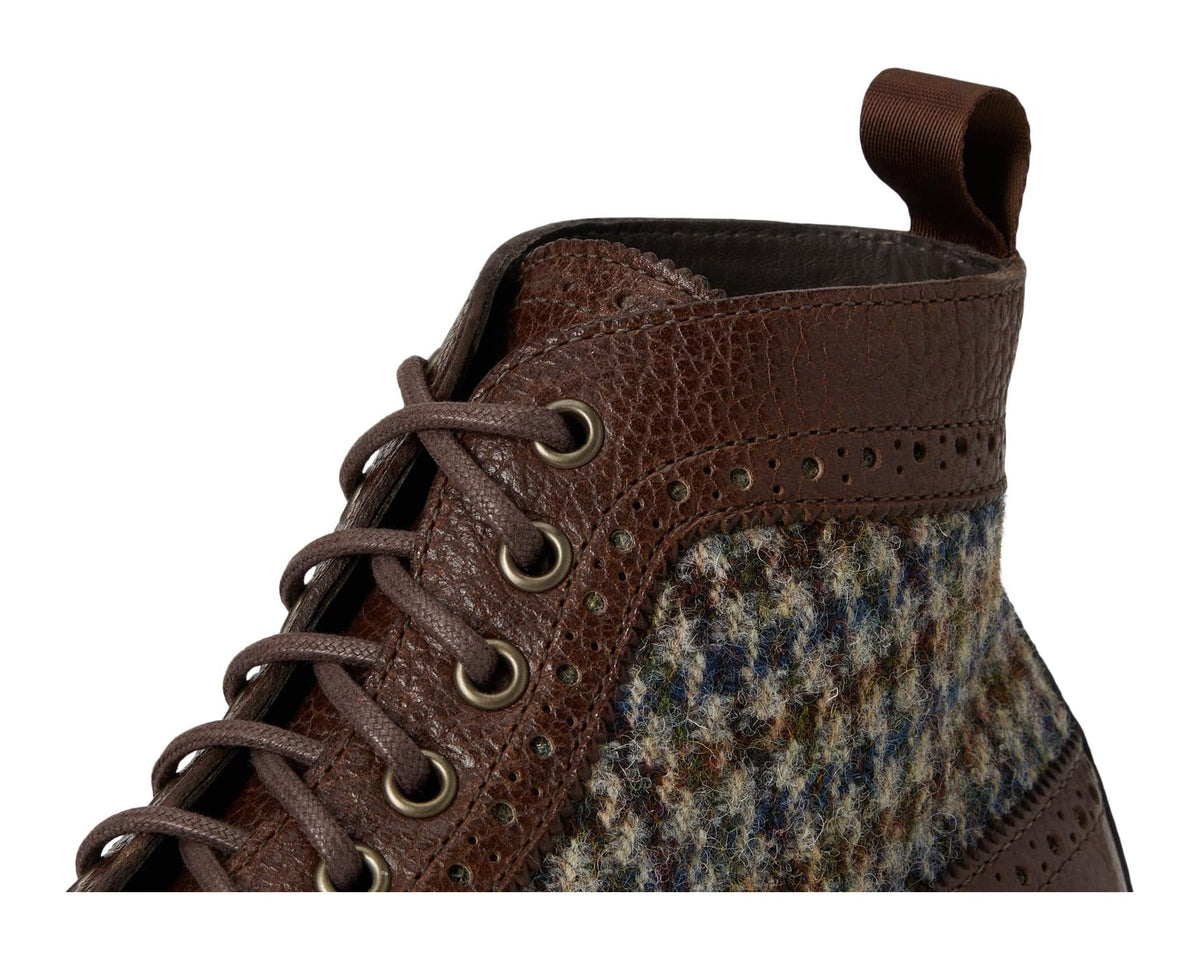 Close-up of brown lace-up ankle boot with tweed tongue and metal eyelets