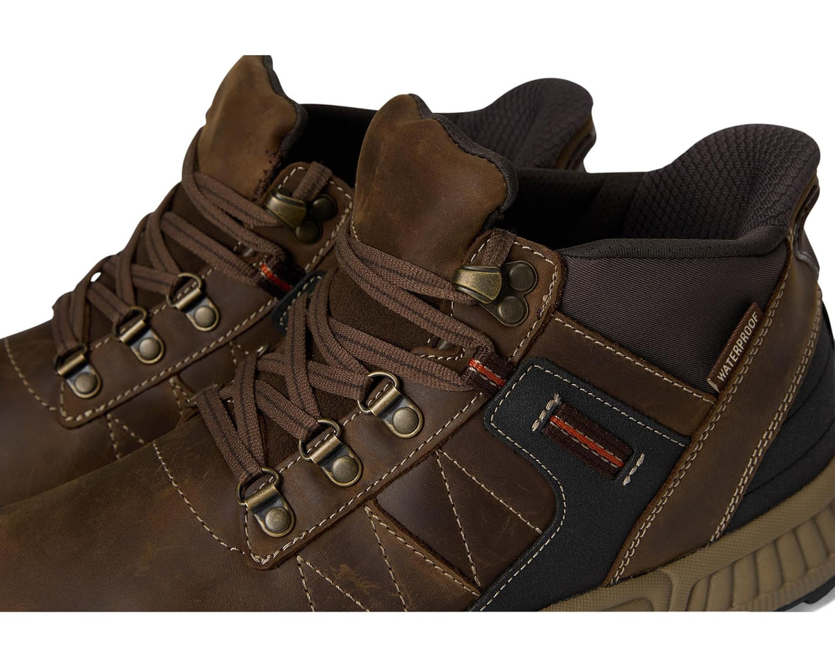 Close-up of brown lace-up ankle boot with metal eyelets and stitched panels