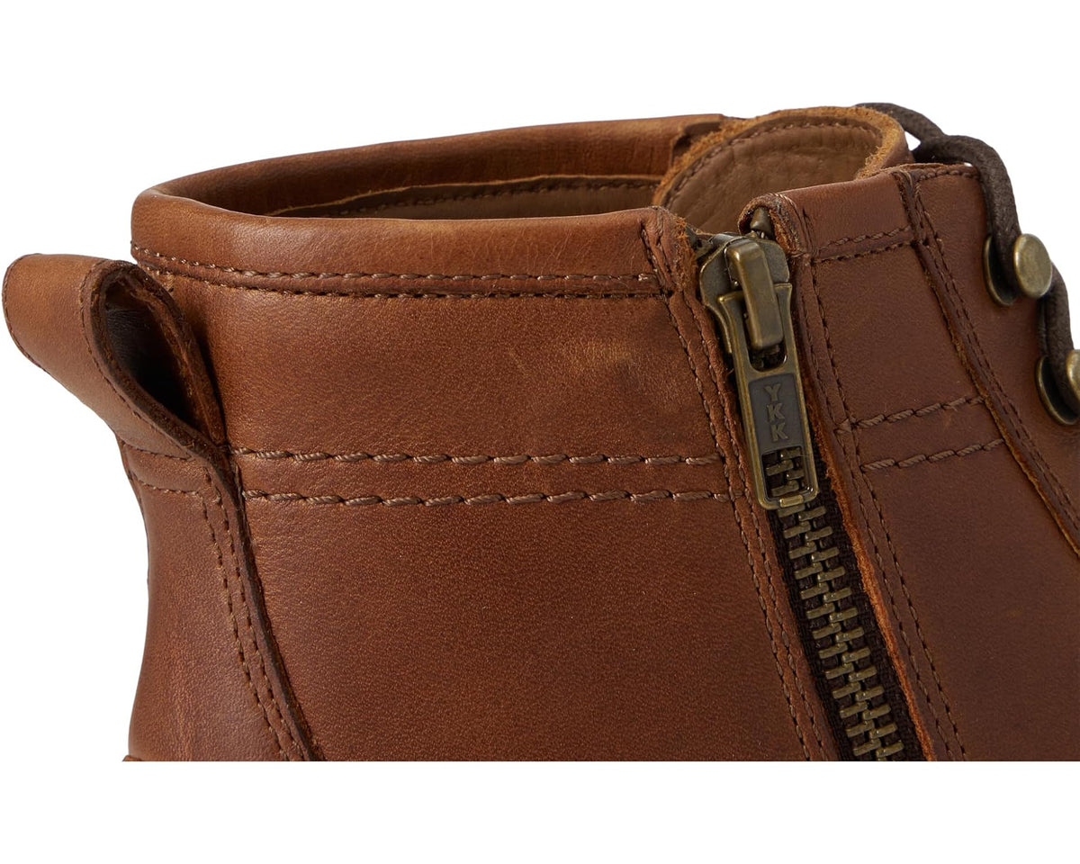 Tan leather ankle boot with side zipper, metal pull tab, and stitched panel detail