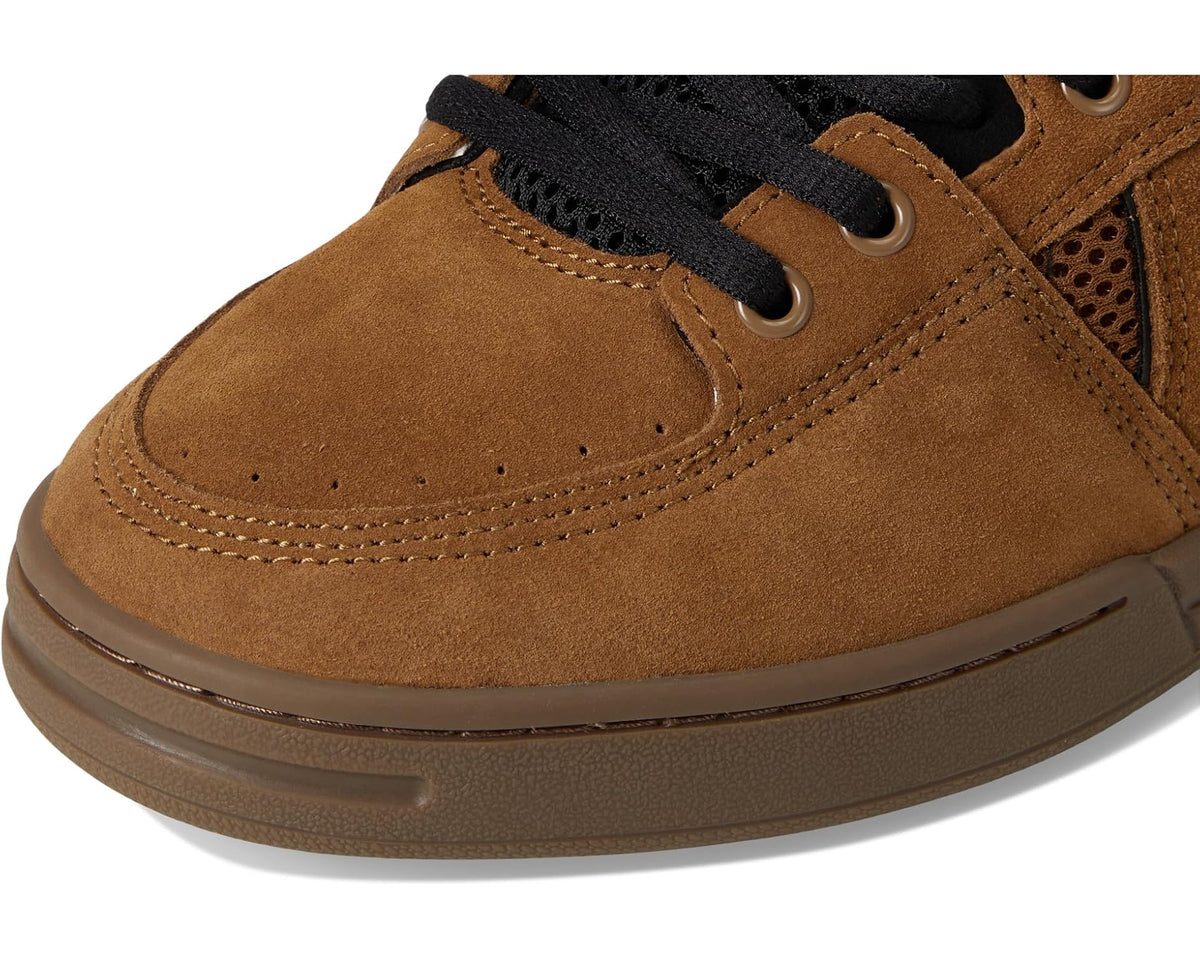 Close-up of brown suede toe with black laces, eyelets, and perforations