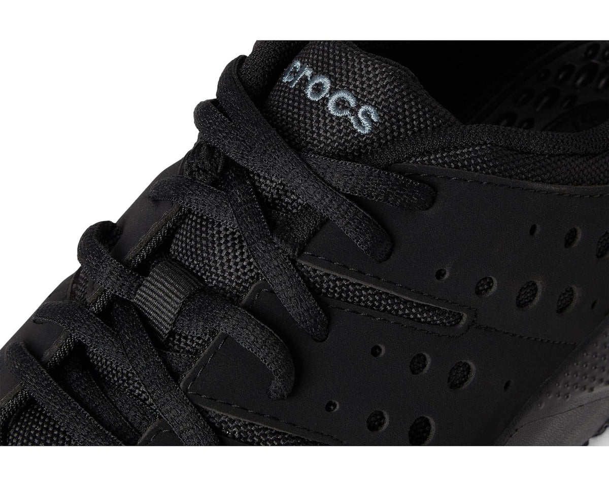 Triple-black sneaker close-up of laces and perforated leather-style panels