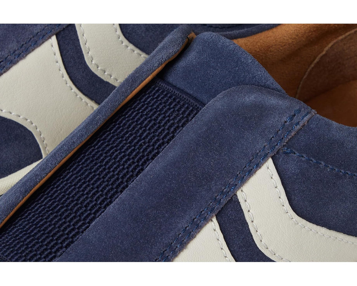 Navy slip-on sneaker close-up with elastic gore detail and contrast stitching