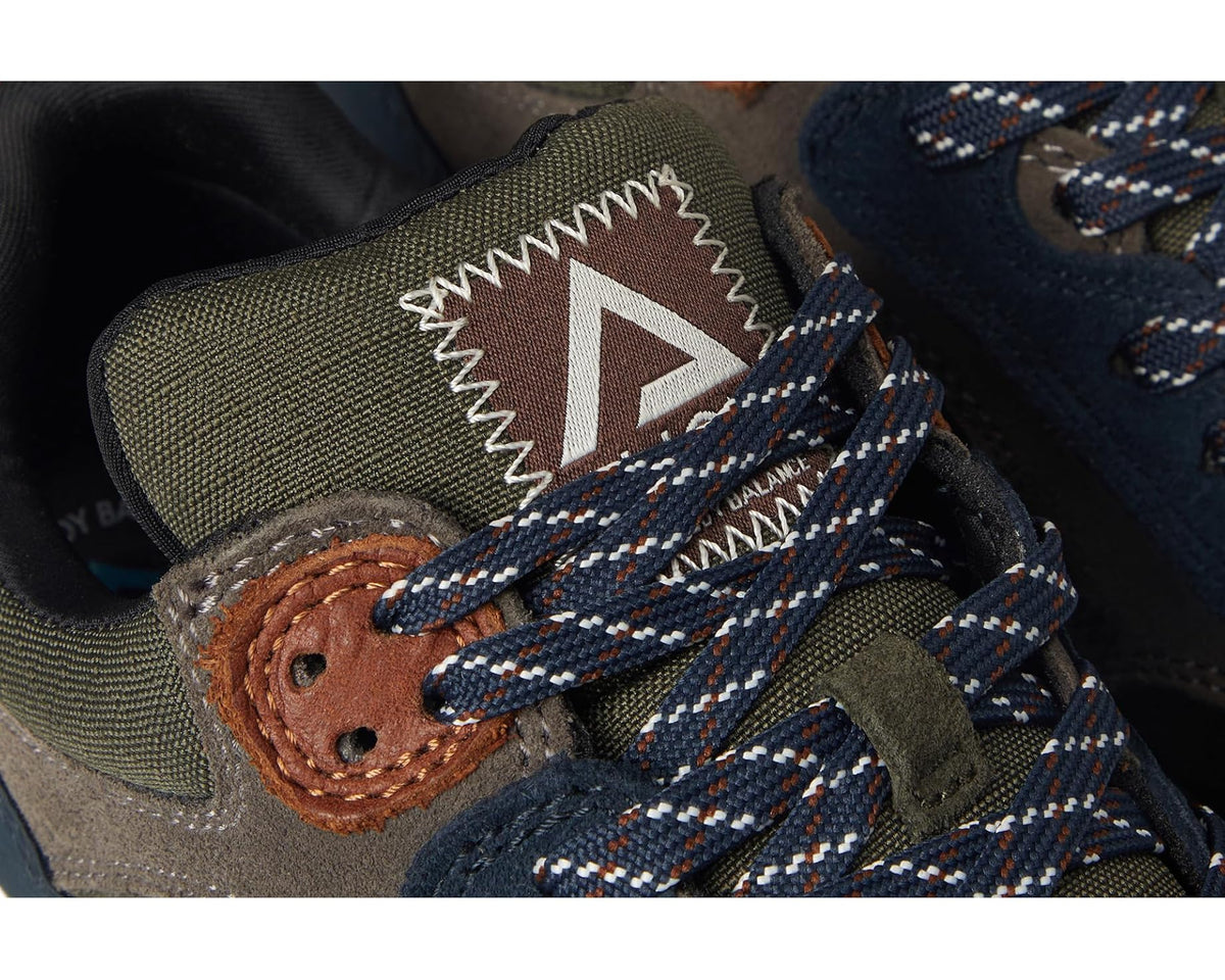 Men's sneaker close-up of patterned laces, brown leather patch, and triangle logo