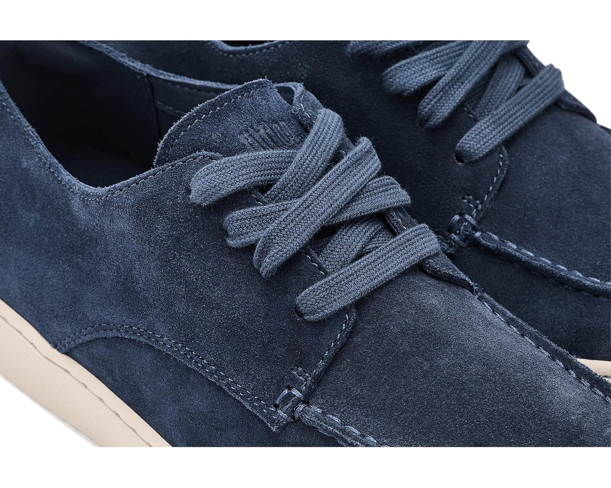 Close-up of midnight navy suede lace-up shoe with stitched seams and eyelets.