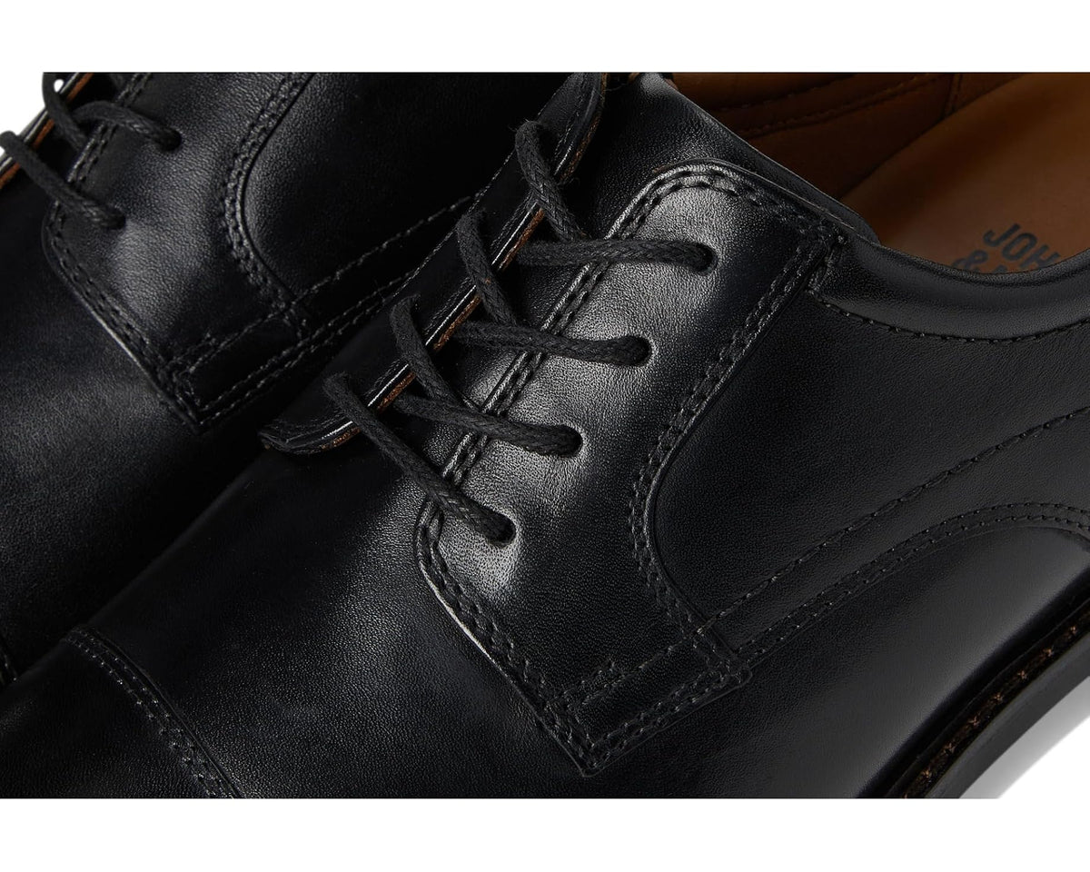 Close-up of black leather oxford laces and stitched seam details near vamp.