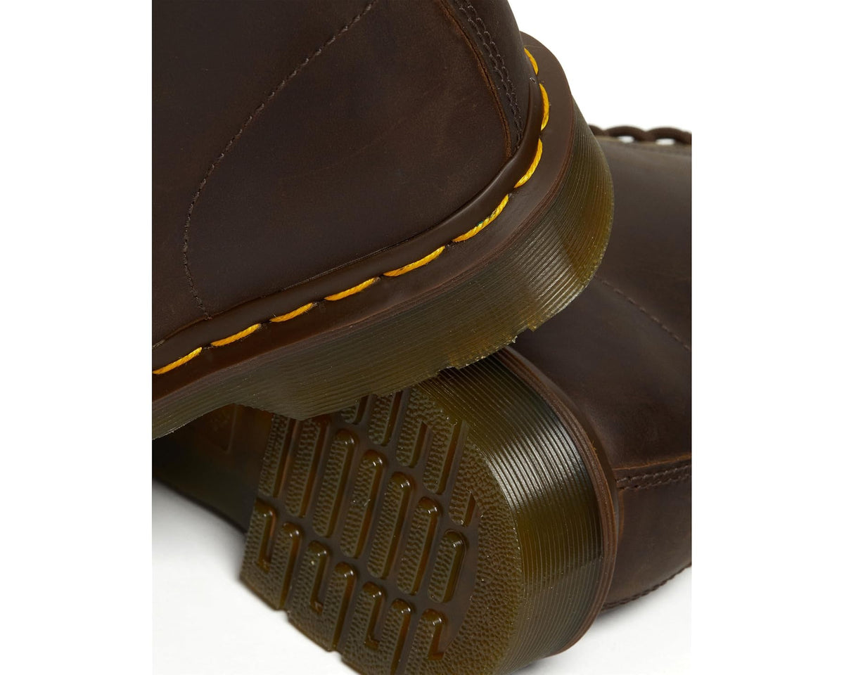 Close-up of dark brown boot with yellow welt stitching and textured tread sole