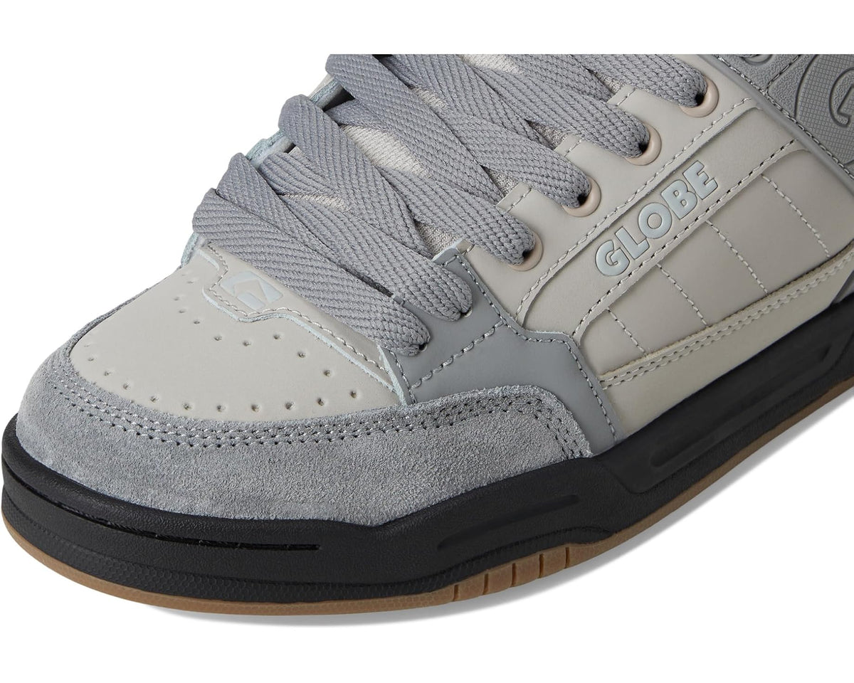 Close-up of low-top sneaker toe and laces in light gray with off-white leather panel details