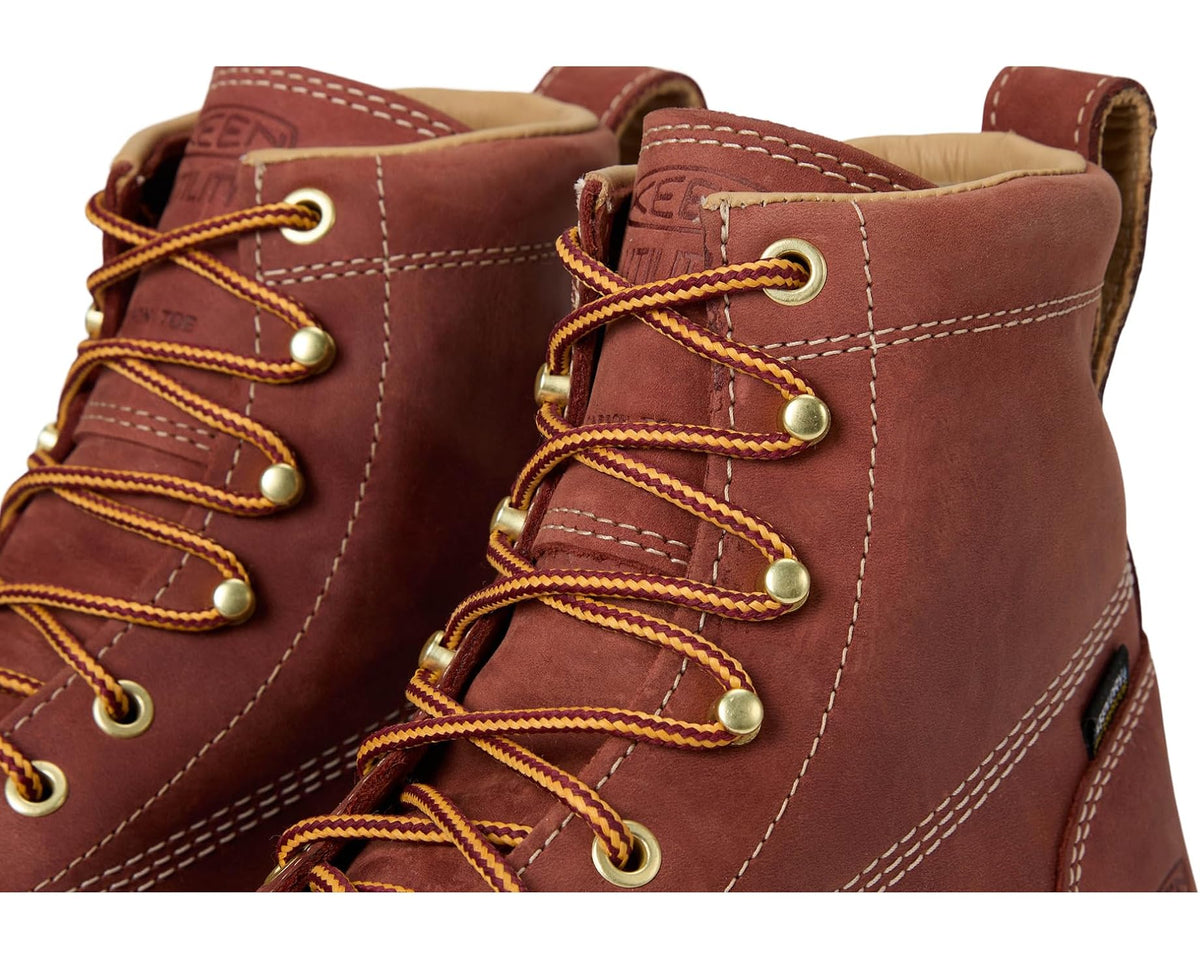 Close-up of men's brown lace-up work boots with yellow rope laces and metal eyelets