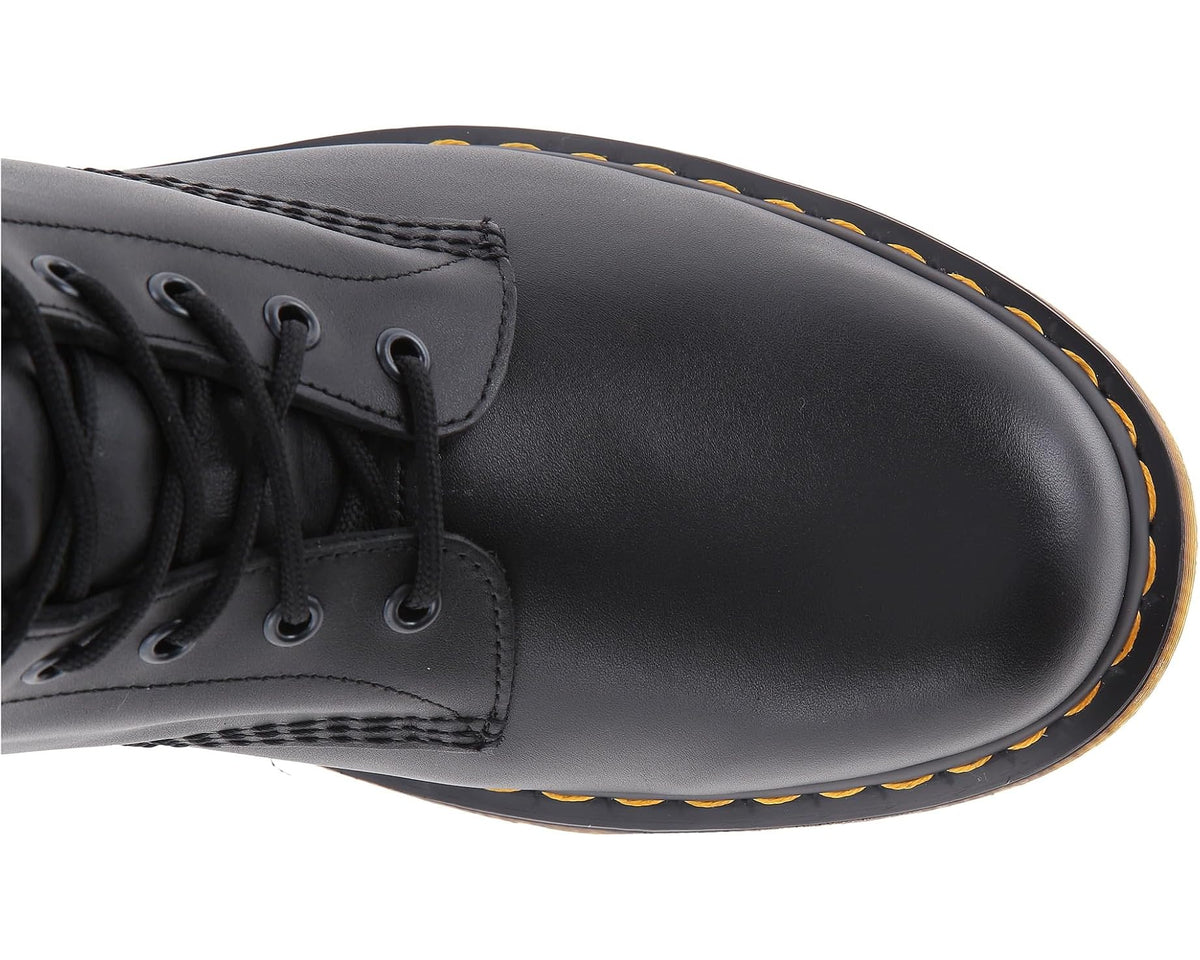 Close-up of black lace-up boot toe with yellow edge stitching and thick sole